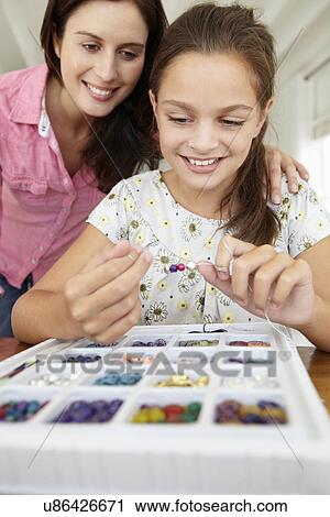 Mother and daughter making jewellery View Large Photo Image Stock Image - Mother and daughter making jewellery. Fotosearch