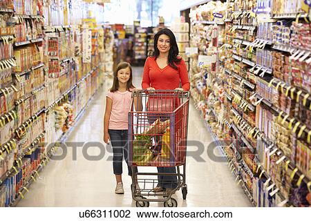 Stock Image - Mother and daughter shopping in supermarket. Fotosearch