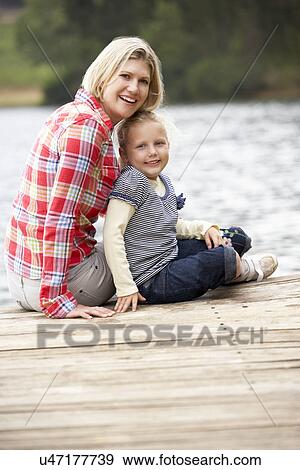 Mother and daughter sitting on a jetty View Large Photo Image Stock Photo - Mother and daughter sitting on a jetty. Fotosearch
