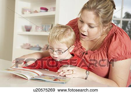Stock Photo - Mother and Downs Syndrome son reading. Fotosearch