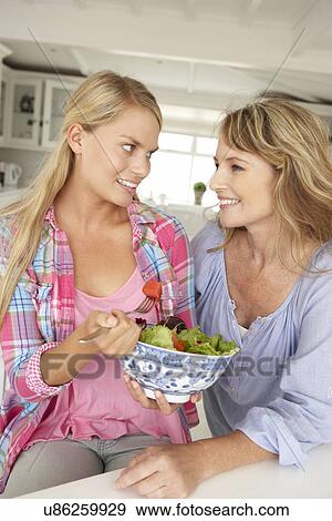 Mother and teenage daughter enjoying food at home View Large Photo Image Stock Photo - Mother and teenage daughter enjoying food at home. Fotosearch