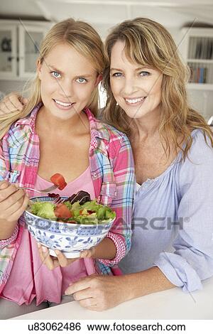 Mother and teenage daughter enjoying food at home View Large Photo Image Stock Photograph - Mother and teenage daughter enjoying food at home. Fotosearch