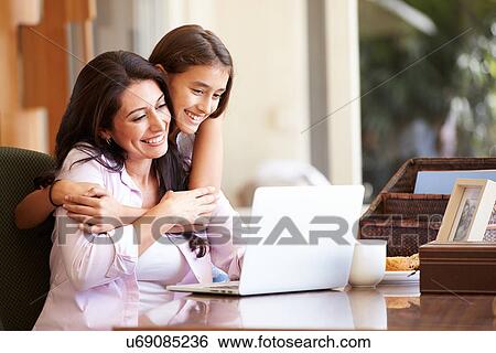 Stock Photograph - Mother And Teenage Daughter Looking At Laptop Together. Fotosearch