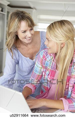 Mother and teenage daughter using laptop View Large Photo Image Picture - Mother and teenage daughter using laptop. Fotosearch