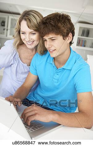 Mother and teenage son using laptop View Large Photo Image Stock Photo - Mother and teenage son using laptop. Fotosearch