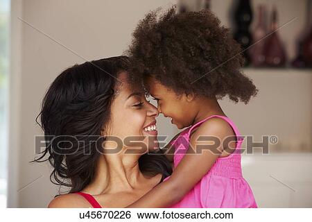 Mother Cuddling Daughter At Home View Large Photo Image Stock Photograph - Mother Cuddling Daughter At Home. Fotosearch