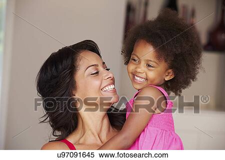 Mother Cuddling Daughter At Home View Large Photo Image Stock Photography - Mother Cuddling Daughter At Home. Fotosearch