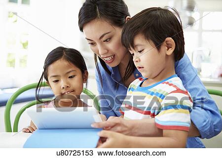 Mother Helping Children With Homework Using Digital Tablet View Large Photo Image Stock Image - Mother Helping Children With Homework Using Digital Tablet. Fotosearch