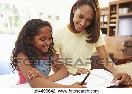 Stock Image - Mother Helping Daughter With Homework. Fotosearch