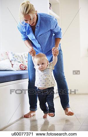 Mother Helping Young Son As He Learns To Walk View Large Photo Image Stock Image - Mother Helping Young Son As He Learns To Walk. Fotosearch