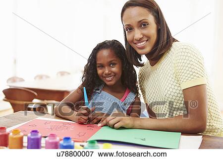 Stock Photo - Mother Painting Picture With Daughter At Home. Fotosearch
