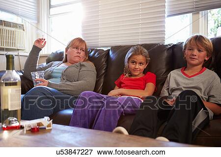 Mother Sits On Sofa With Children Smoking And Drinking View Large Photo Image Stock Photo - Mother Sits On Sofa With Children Smoking And Drinking. Fotosearch