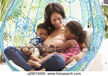 Stock Photography - Mother With Children Relaxing On Outdoor Garden Swing Seat. Fotosearch