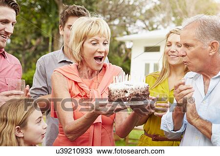 Stock Image - Multi Generation Family Celebrating Birthday In Garden. Fotosearch