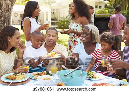 Multi Generation Family Enjoying Meal In Garden Together View Large Photo Image Stock Image - Multi Generation Family Enjoying Meal In Garden Together. Fotosearch