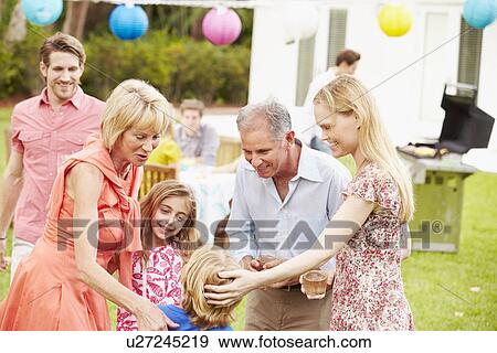 Multi Generation Family Enjoying Meal In Garden Together View Large Photo Image Stock Photo - Multi Generation Family Enjoying Meal In Garden Together. Fotosearch