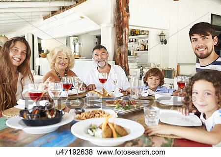 Multi Generation Family Enjoying Meal In Restaurant View Large Photo Image Stock Photo - Multi Generation Family Enjoying Meal In Restaurant. Fotosearch