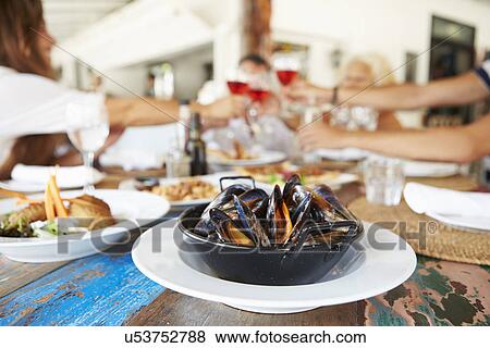 Stock Photo - Multi Generation Family Enjoying Meal In Restaurant. Fotosearch