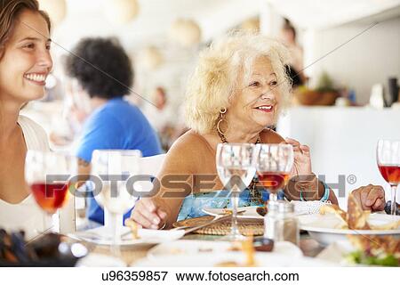 Multi Generation Family Enjoying Meal In Restaurant View Large Photo Image Stock Photo - Multi Generation Family Enjoying Meal In Restaurant. Fotosearch