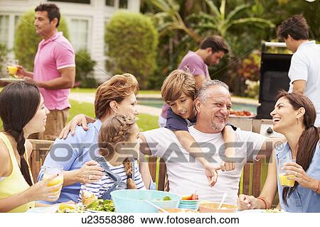 Multi Generation Family Enjoying Meal In Garden Together View Large Photo Image Stock Photograph - Multi Generation Family Enjoying Meal In Garden Together. Fotosearch