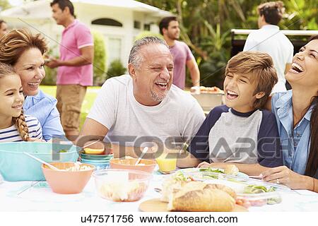 Multi Generation Family Enjoying Meal In Garden Together View Large Photo Image Stock Photograph - Multi Generation Family Enjoying Meal In Garden Together. Fotosearch