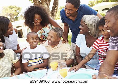 Multi Generation Family Enjoying Meal In Garden Together View Large Photo Image Stock Photograph - Multi Generation Family Enjoying Meal In Garden Together. Fotosearch