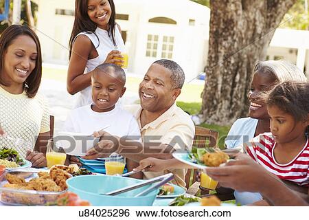 Multi Generation Family Enjoying Meal In Garden Together View Large Photo Image Stock Photograph - Multi Generation Family Enjoying Meal In Garden Together. Fotosearch