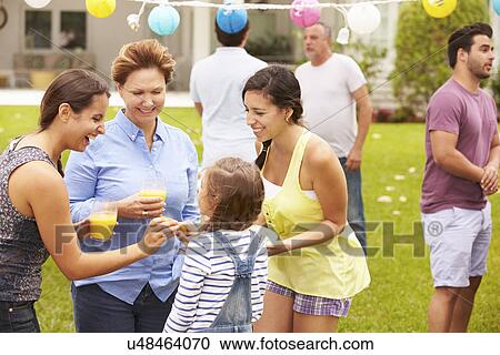Stock Image - Multi Generation Family Enjoying Party In Garden Together. Fotosearch