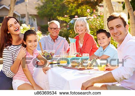 Multi-Generation Family Enjoying Outdoor Meal In Garden View Large Photo Image Picture - Multi-Generation Family Enjoying Outdoor Meal In Garden. Fotosearch