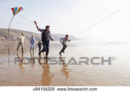 Multi Generation Family Flying Kite On Winter Beach View Large Photo Image Stock Photo - Multi Generation Family Flying Kite On Winter Beach. Fotosearch