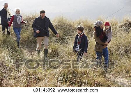 Stock Image - Multi Generation Family In Sand Dunes On Winter Beach. Fotosearch