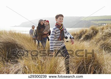 Stock Photo - Multi Generation Family In Sand Dunes On Winter Beach. Fotosearch