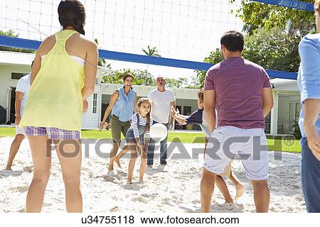 Stock Photo - Multi Generation Family Playing Volleyball In Garden. Fotosearch