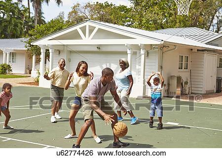 Stock Photograph - Multi Generation Family Playing Basketball Together. Fotosearch