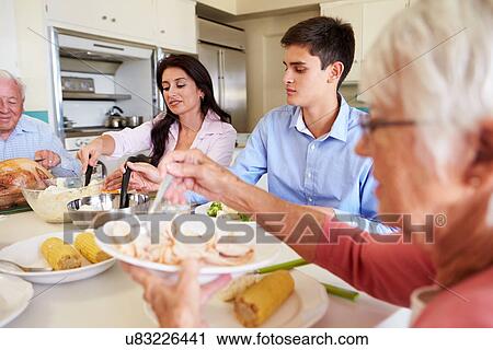 Multi-Generation Family Sitting Around Table Eating Meal View Large Photo Image Stock Image - Multi-Generation Family Sitting Around Table Eating Meal. Fotosearch