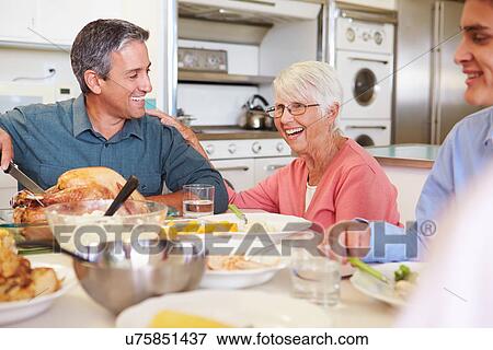 Multi-Generation Family Sitting Around Table Eating Meal View Large Photo Image Stock Photo - Multi-Generation Family Sitting Around Table Eating Meal. Fotosearch