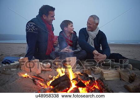 Multi Generation Family Sitting By Fire On Winter Beach View Large Photo Image Stock Photo - Multi Generation Family Sitting By Fire On Winter Beach . Fotosearch