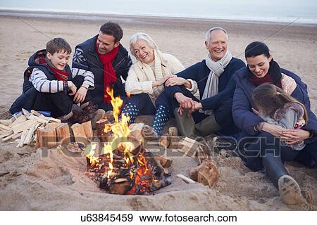 Multi Generation Family Sitting By Fire On Winter Beach View Large Photo Image Stock Photo - Multi Generation Family Sitting By Fire On Winter Beach . Fotosearch
