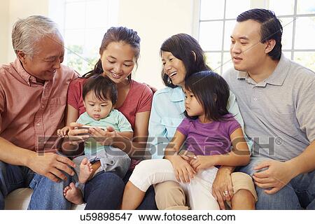 Multi Generation Family Sitting On Sofa With Mobile Phone View Large Photo Image Stock Photo - Multi Generation Family Sitting On Sofa With Mobile Phone. Fotosearch