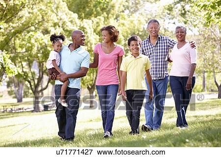 Multi-generation family walking in park View Large Photo Image Stock Photo - Multi-generation family walking in park. Fotosearch