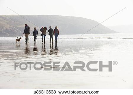 Stock Photo - Multi Generation Family Walking On Winter Beach With Dog. Fotosearch