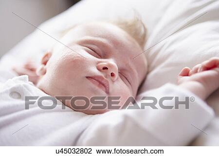 Stock Image - Newborn Baby Girl Sleeping In Bed. Fotosearch