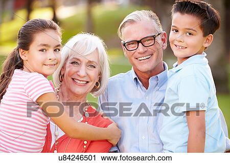 Stock Image - Outdoor Portrait Of Grandparents With Grandchildren In Park. Fotosearch