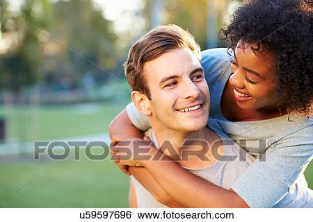 Stock Photograph - Outdoor Portrait Of Romantic Young Couple In Park. Fotosearch