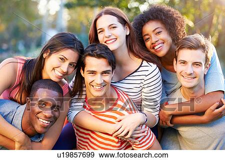 Stock Photo - Outdoor Portrait Of Young Friends Having Fun In Park. Fotosearch