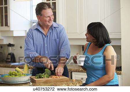 Stock Image - Overweight Couple On Diet Preparing Vegetables In Kitchen. Fotosearch