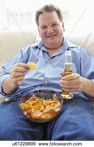 Overweight Man At Home Eating Chips And Drinking Beer View Large Photo Image Stock Photo - Overweight Man At Home Eating Chips And Drinking Beer. Fotosearch