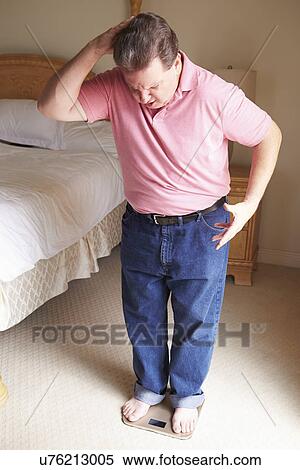 Overweight Man Weighing Himself On Scales In Bedroom View Large Photo Image Stock Photography - Overweight Man Weighing Himself On Scales In Bedroom. Fotosearch