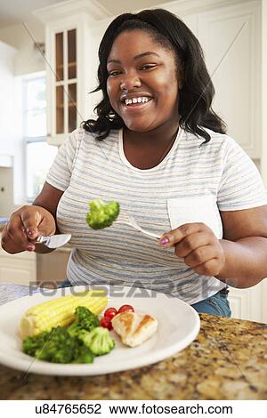 Overweight Woman Eating Healthy Meal in Kitchen View Large Photo Image Stock Image - Overweight Woman Eating Healthy Meal in Kitchen. Fotosearch