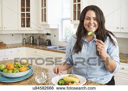 Overweight Woman Eating Healthy Meal In Kitchen View Large Photo Image Stock Photograph - Overweight Woman Eating Healthy Meal In Kitchen. Fotosearch